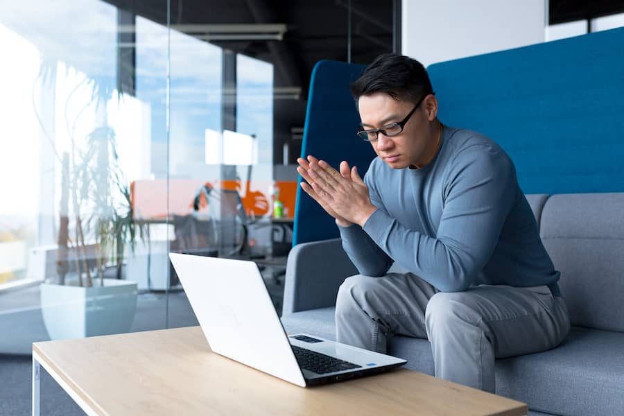 man working in office sitting at couch